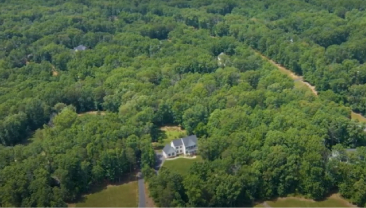 An aerial view of a property surrounded by a forest